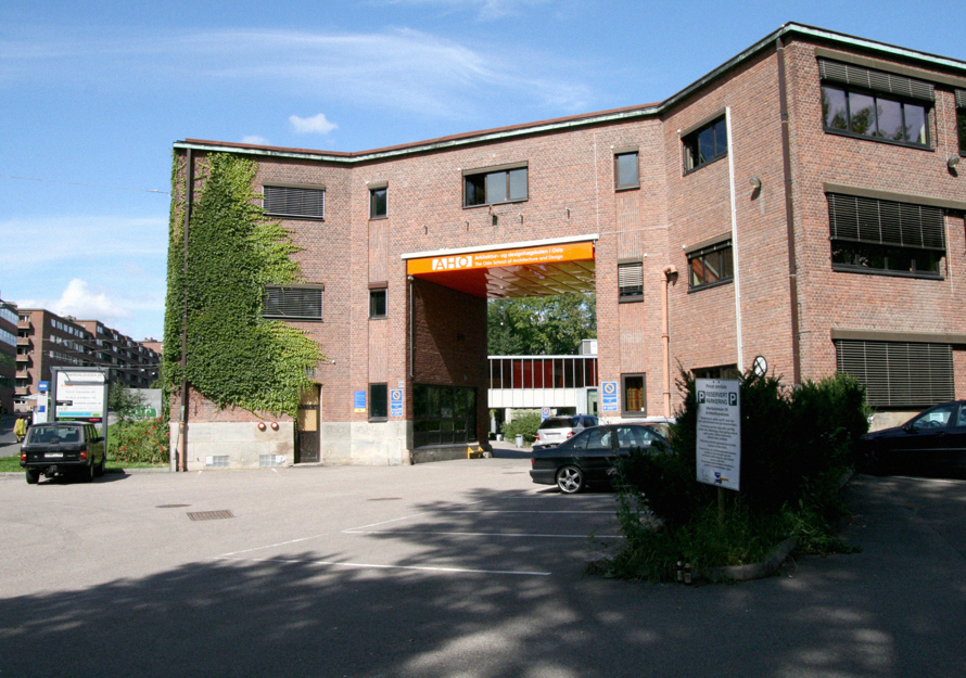 Portalen inn til arkitektur og design-høgskolen i Oslo med parkeringsplassen i forgrunnen. Foto.