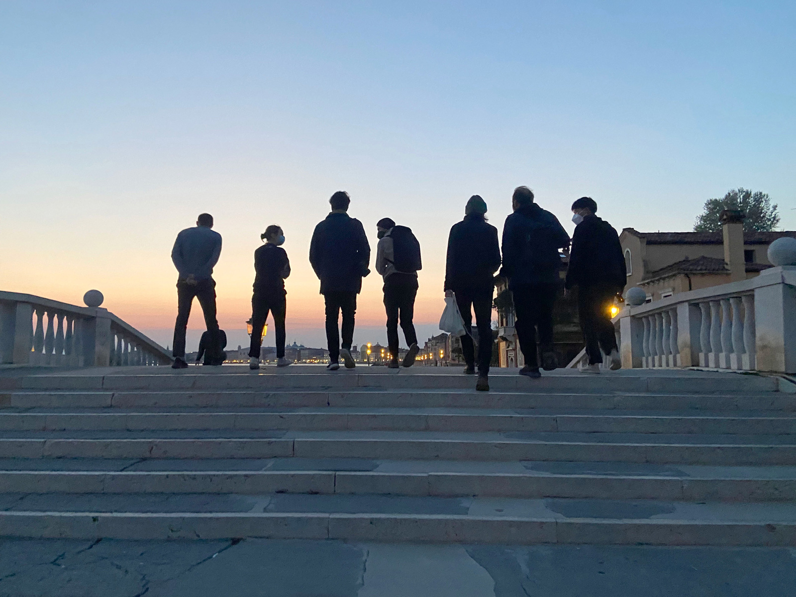 Foto av folk i solnedgang gå fra biennalen.