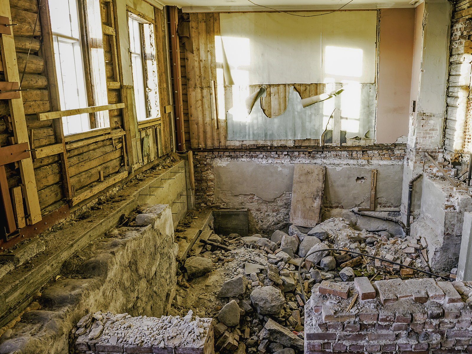 Foto av interiøret ved start på ombygging av festiviteten, nedslitte vegger, manglende gulv med mer. 