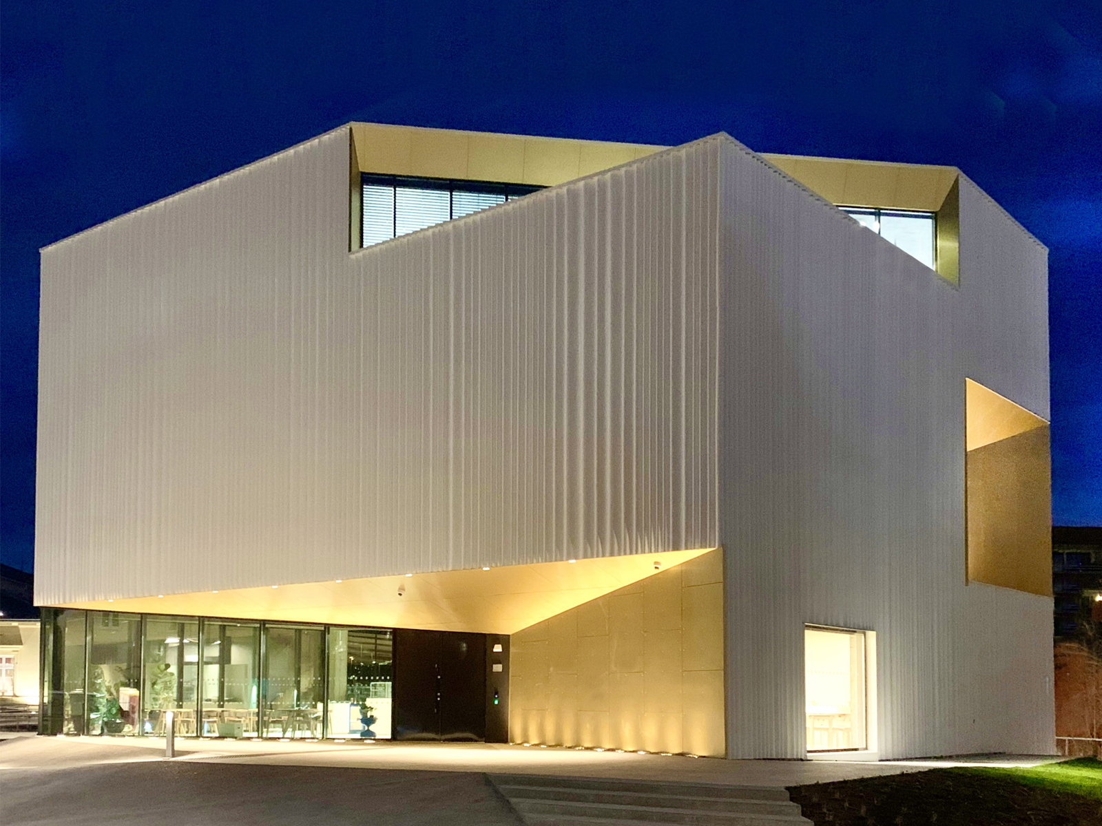 Hvitt bygg med spiss vinkel mot kamera. Foto.