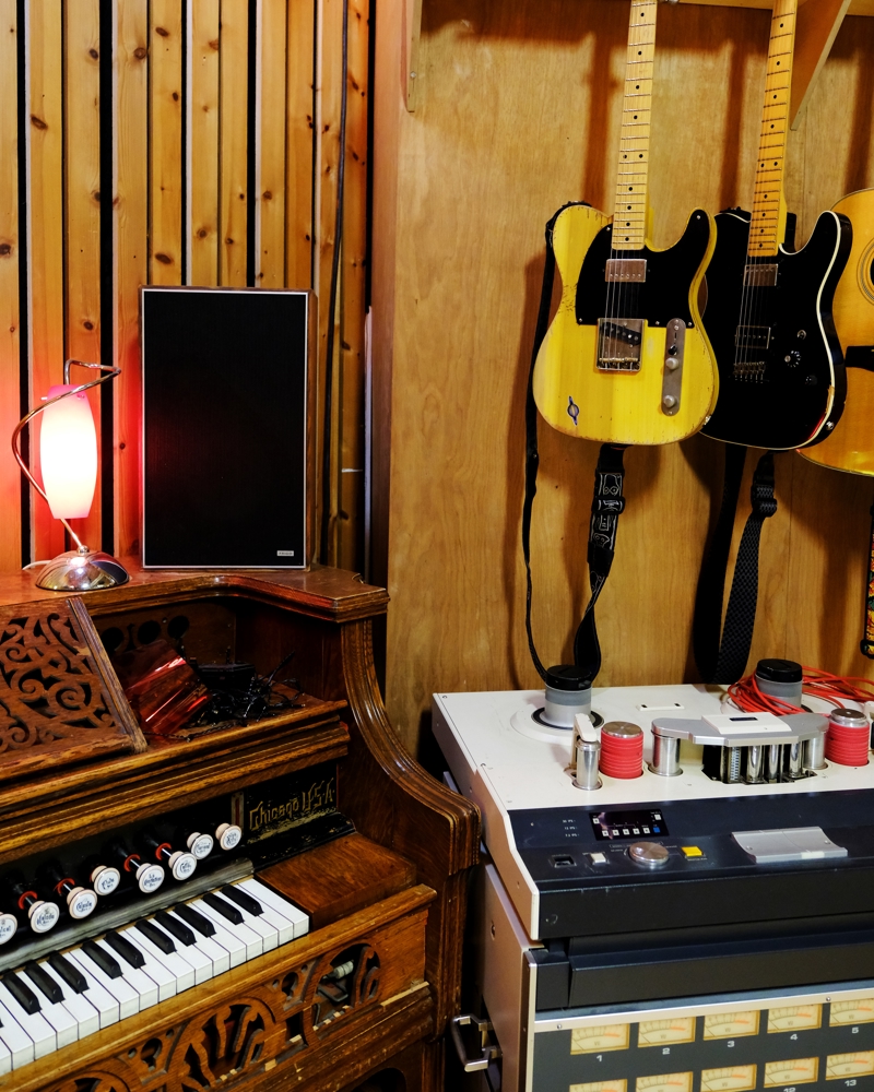 Foto av orgel, gitar og andre ting inntil en vegg.