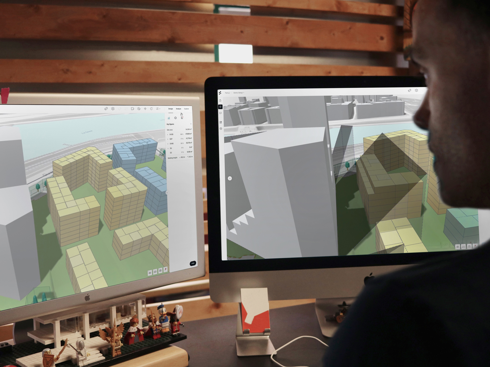 Mann som 3D-modellerer bygg på to Pc-skjermer. Foto.