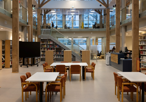 Interiør foto av et større åpent bibliotekrom, sittegrupper, trapp dobbelthøyt rom.