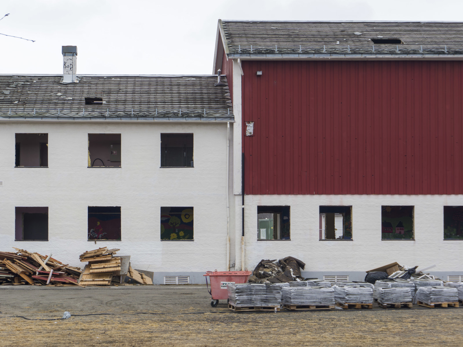 Foto av hvit og rød internatskole uten innsatte vinduer. 