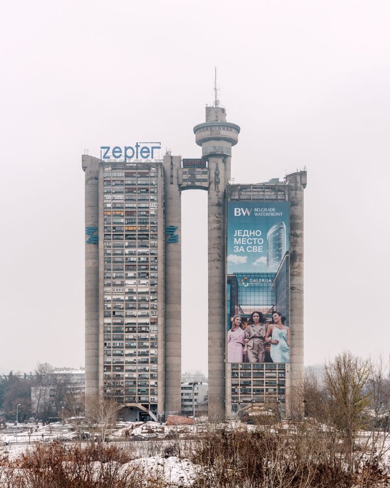 Foto av ett høyt betong bygg i urbant vinterlandskap.