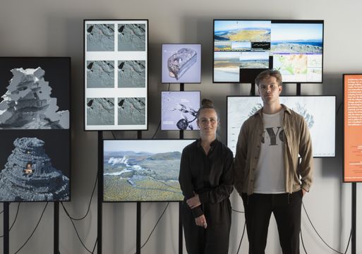 Foto av Arnhildur Pálmadóttir og Arnar Skarphéðinsson fremfor utstilling på skjermer. 