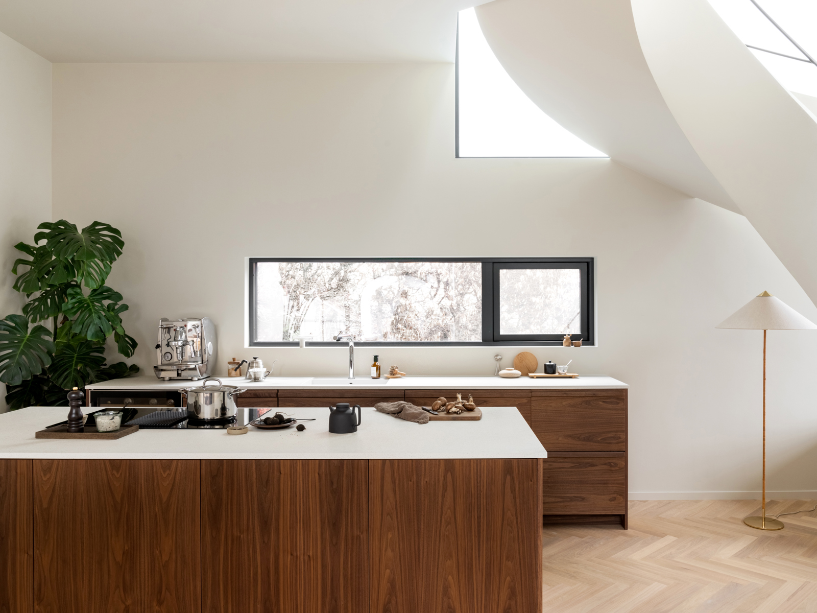 Interiør foto av kjøkken med trapp som kommer svingende ned på siden.