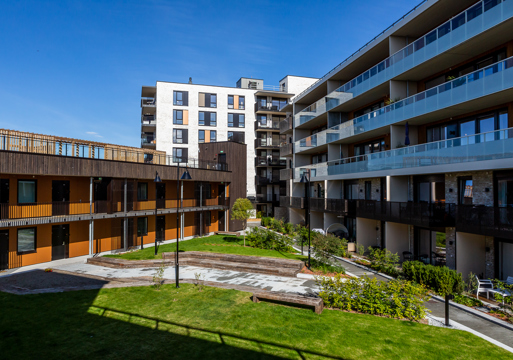 Foto av bakgård mellom leilighetsbygg. 
