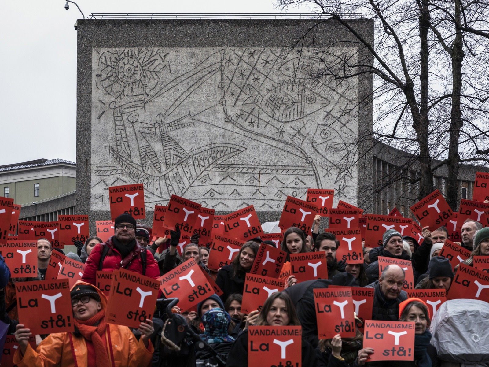Fotografi som viser demonstranter foran verket «Fiskerne» av Pablo Picasso og Carl Nesjar. 