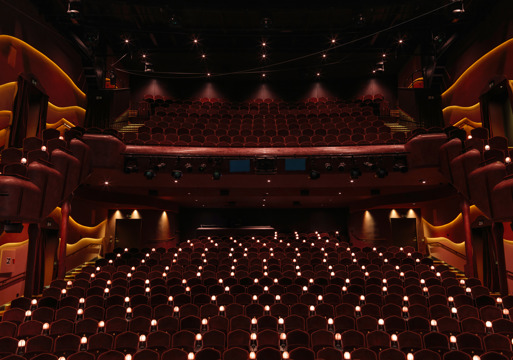 Interiørfoto av publikumssalen i Nye hjorten teater, små lamper ved stolene og to høyder med amfi.