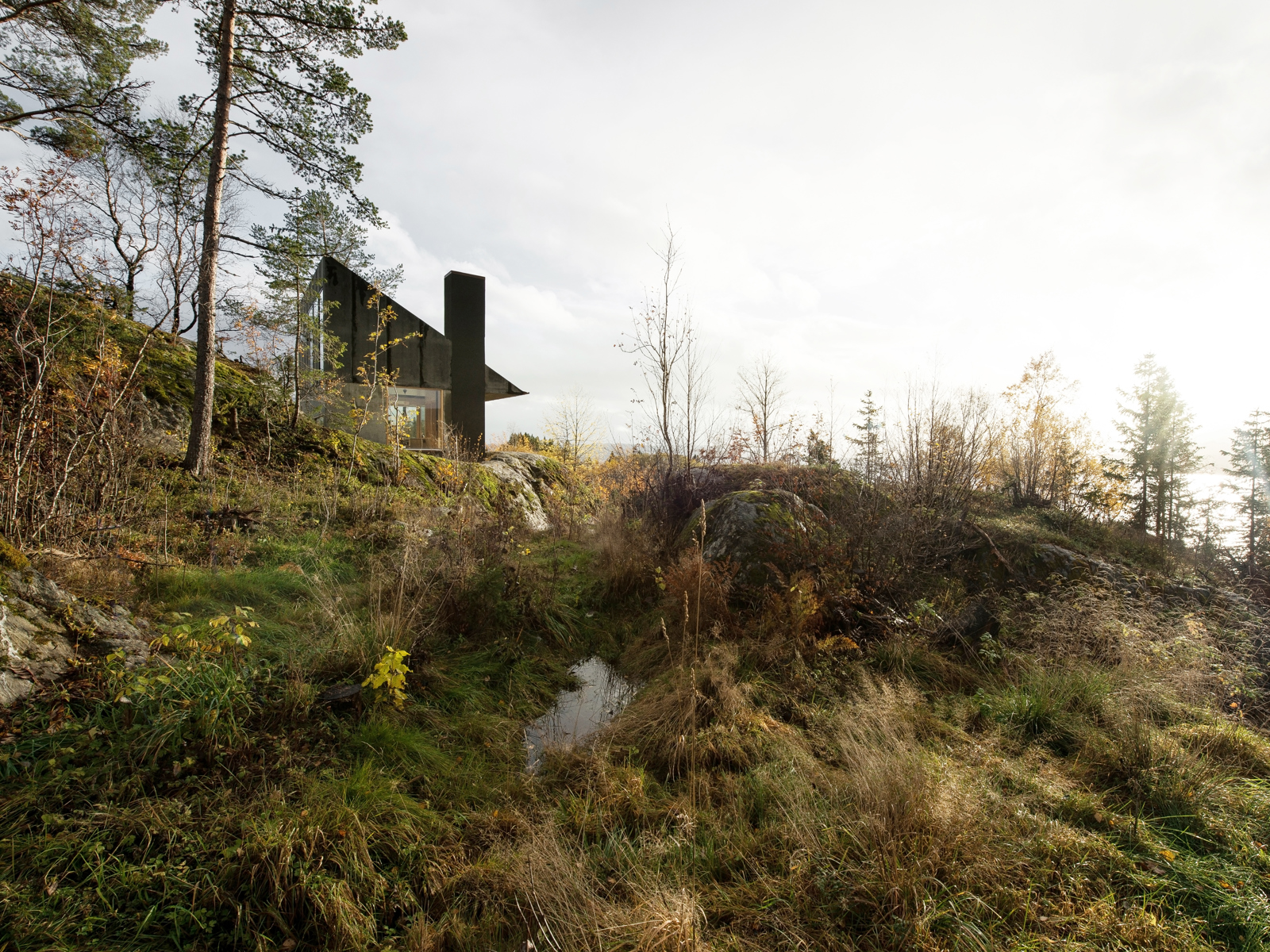 Foto av hytta i et grønt landskap.