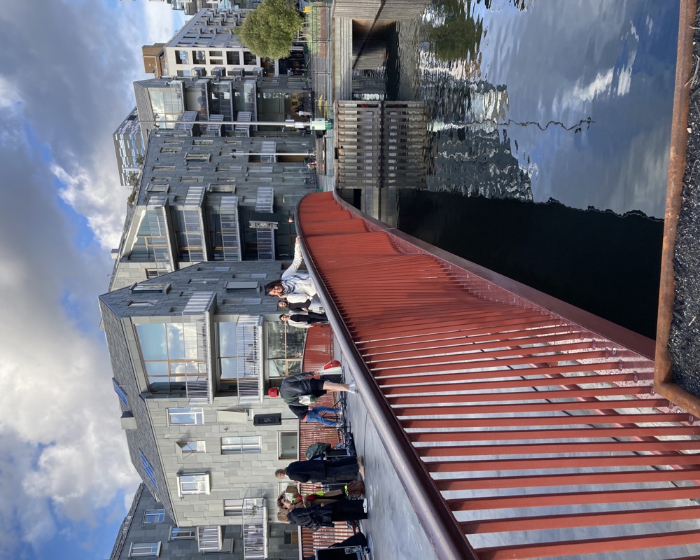 Foto av den røde grunningen bru som viser det buet stålkasse og det åpne rekkverket som har bølgeform