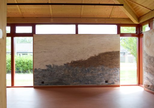 Interiør foto av rom med en vegg av tovet ull midt i, vinduer rundt.