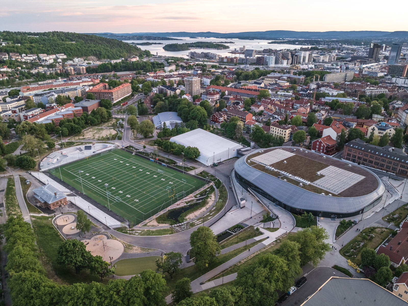 Oversiktbilde over idrettsområde og park i bykontekst. Foto.