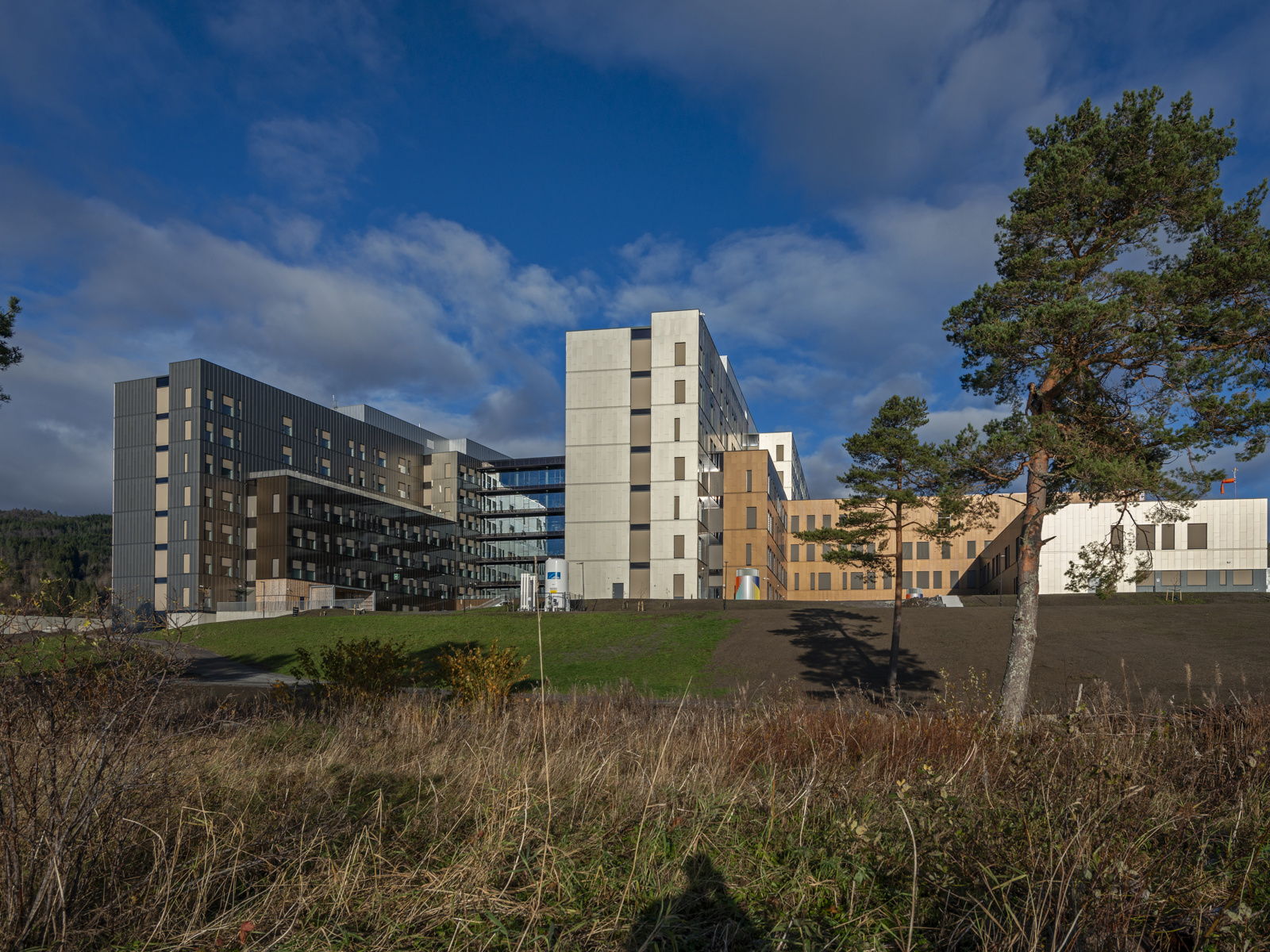 Foto av sør fasaden på Sjukehuset Nordmøre og Romsdal i solskinn.