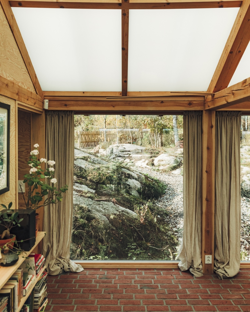 Interiør foto, tegl gulv, stort vindu med utsikt til berg.