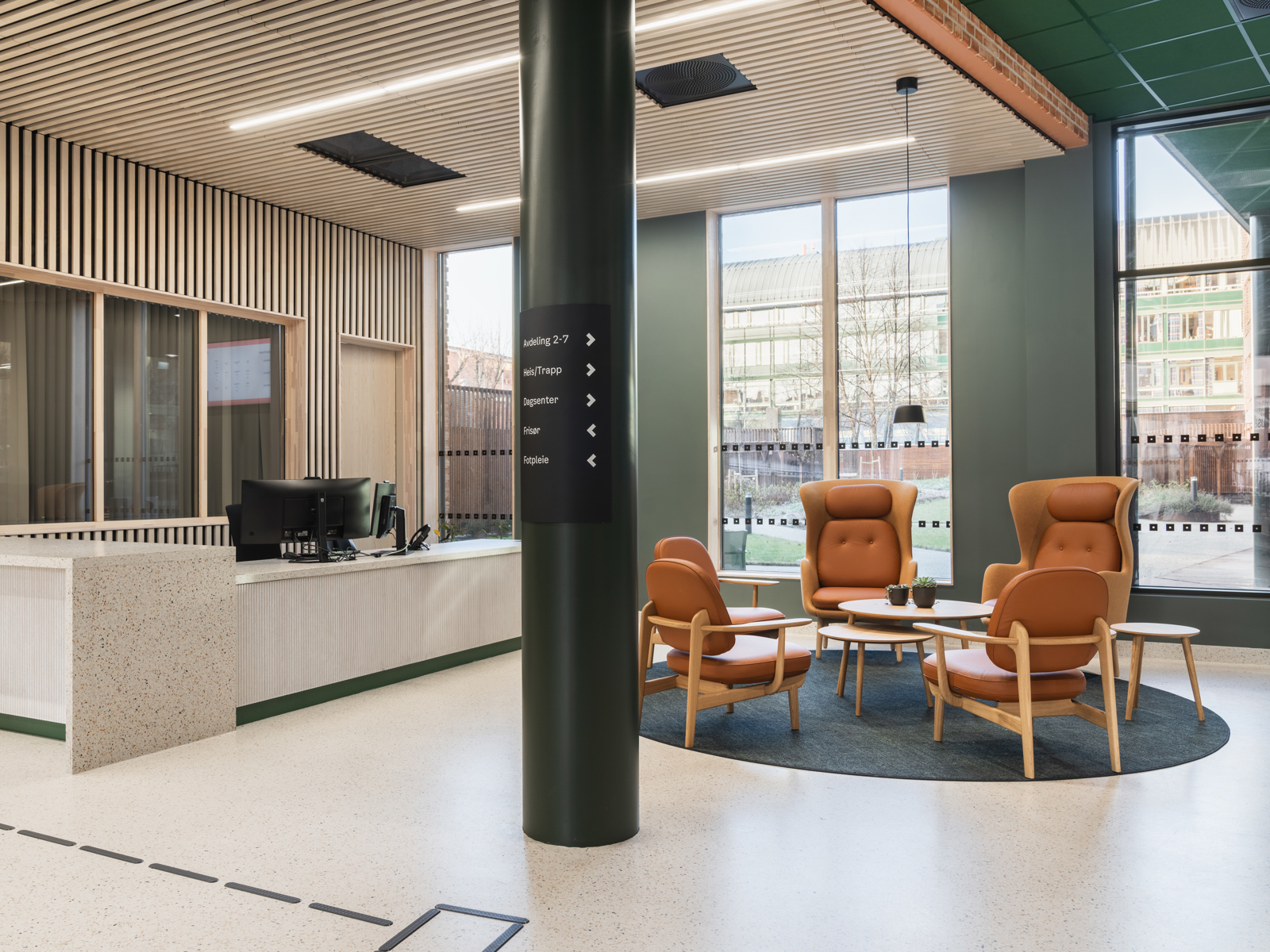 Interiør foto av foajé i Majorstuhjemmet, med sittegrupper, resepsjonsdisk og skilt.