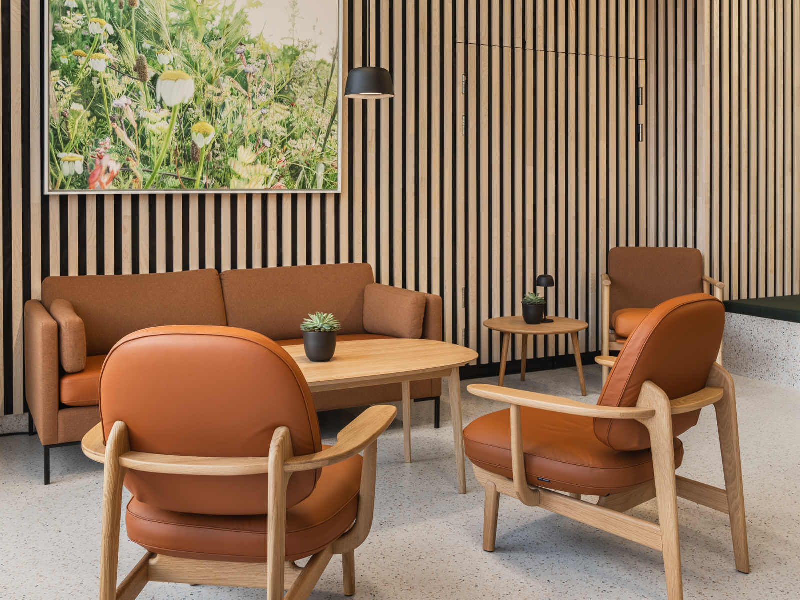 Interiørfoto av fellesområde i Majurstuhjemmet, sittegruppe i oransje toner og treverk.