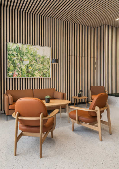 Interiørfoto av fellesområde i Majurstuhjemmet, sittegruppe i oransje toner og treverk.