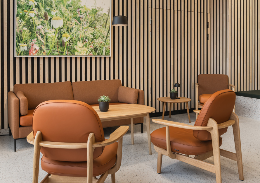 Interiørfoto av fellesområde i Majurstuhjemmet, sittegruppe i oransje toner og treverk.