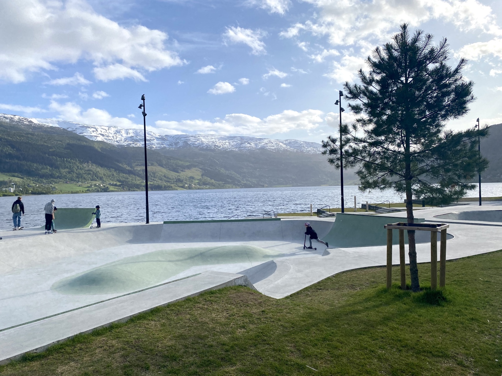 Foto av skatepark, vann og fjell i bakgrunnen. 