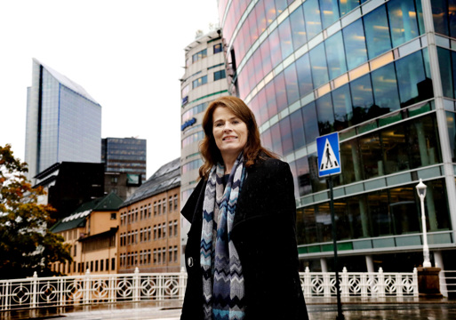 Direktør for Plan- og bygningsetaten i Oslo, Siri G. Kielland, avbildet på Hausmanns bru, med DN Media Group-bygget i bakgrunnen til høyre, og Oslo Plaza lenger bak til venstre. Foto.