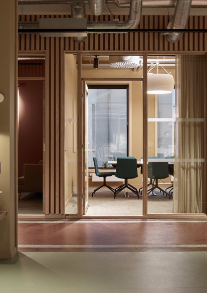 Interiørfoto som viser kontorlokaler i rødlige farger. 