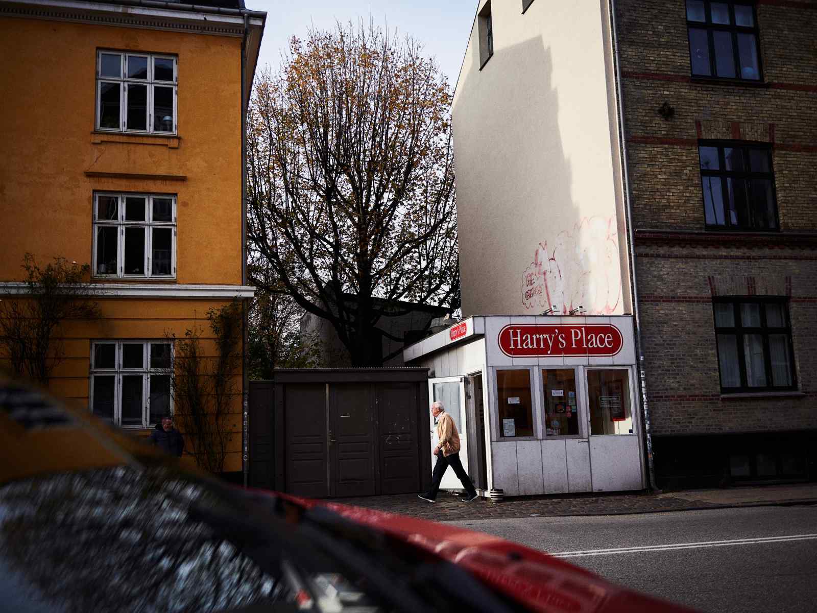 Foto av en liten pølse kiosk mellom to blokker.