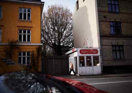 Foto av en liten pølse kiosk mellom to blokker.