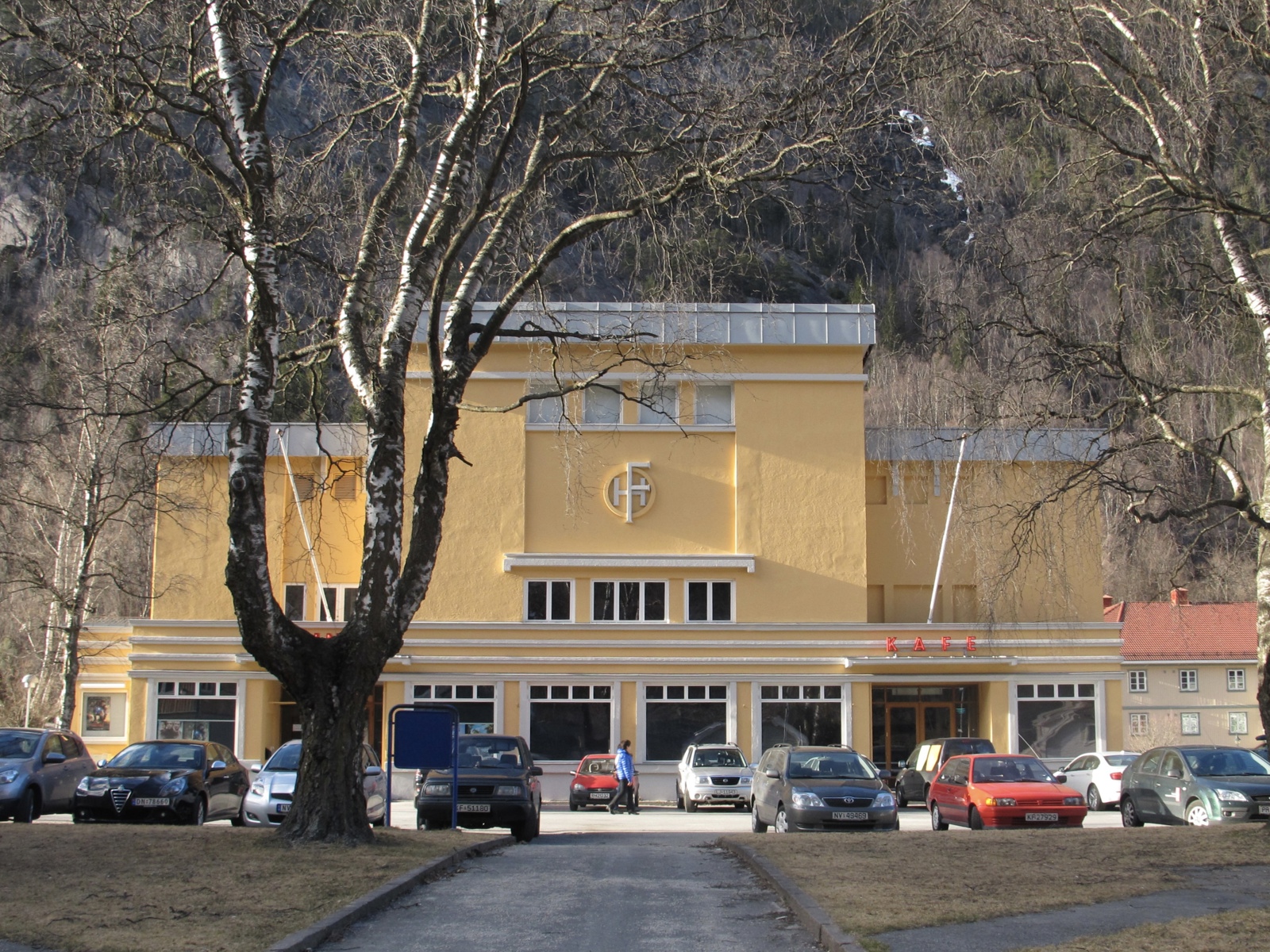 Eksteriørfoto av Folkets Hus på Rjukan. Fasaden er i funkis-stil med gul murpuss og hvite detaljer