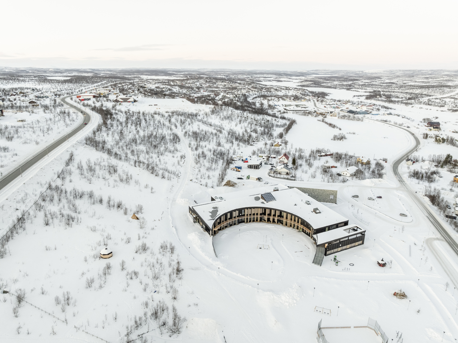 Dronefoto av skole i snølandskap. 