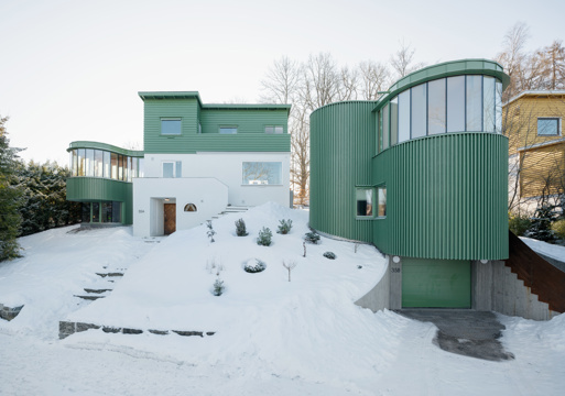 Eksteriør foto av grønn enebolig med kurvet form. 