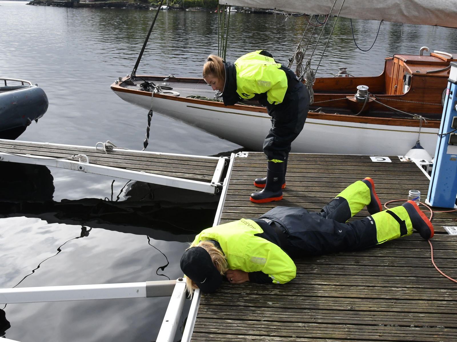 Foto av to mennesker som kikker over kanten på en brygge. 