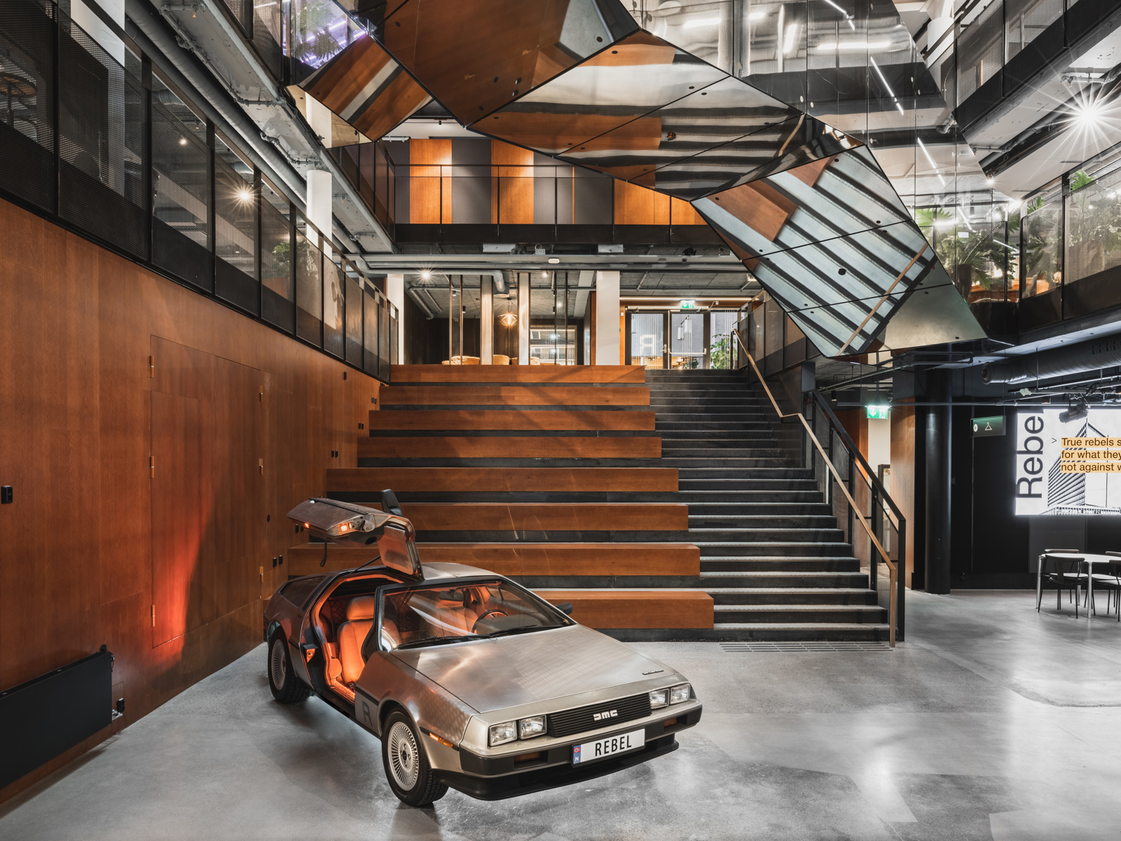 Interiør foto av trappeområde, reflektrende trapp og en bil stående på gulvet.