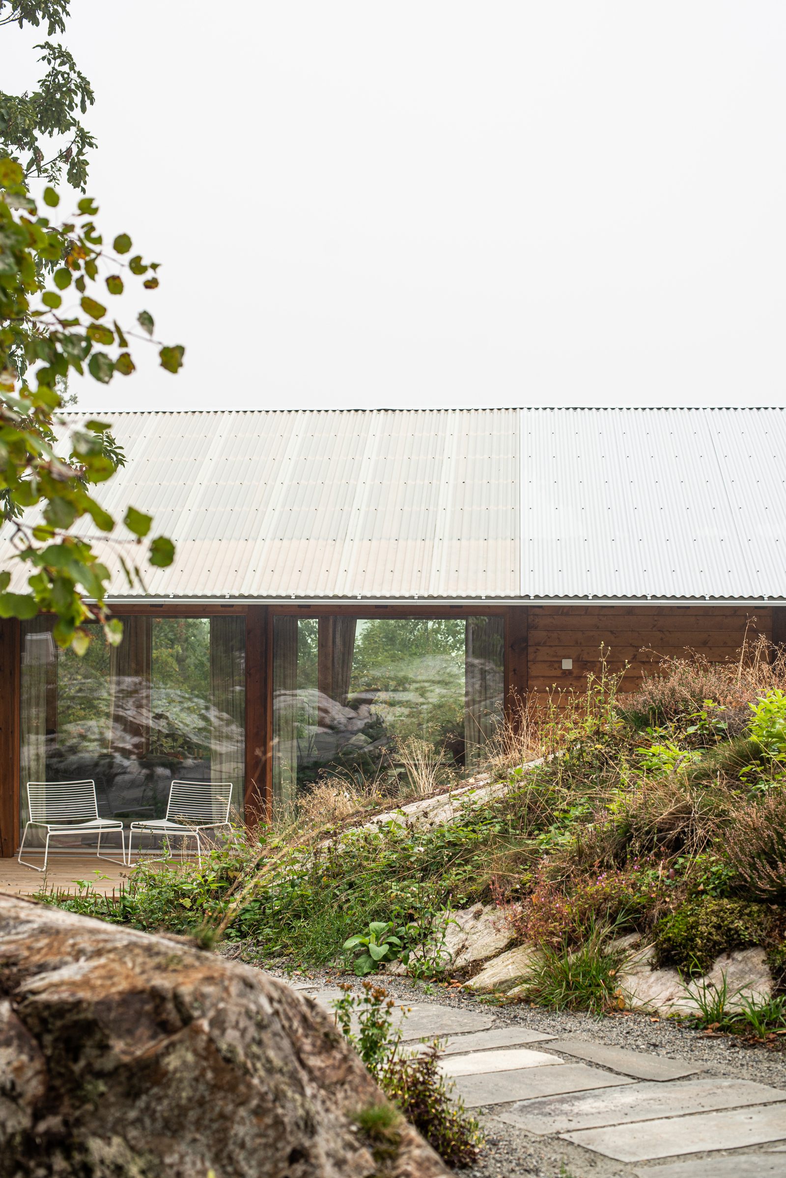 Eksteriør foto av hus i treverk, natur og berg i forgrunnen.
