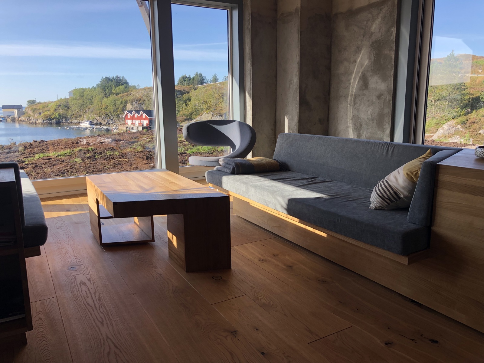Foto av stue med tilpassede møbler i treverk, utsikt til natur.