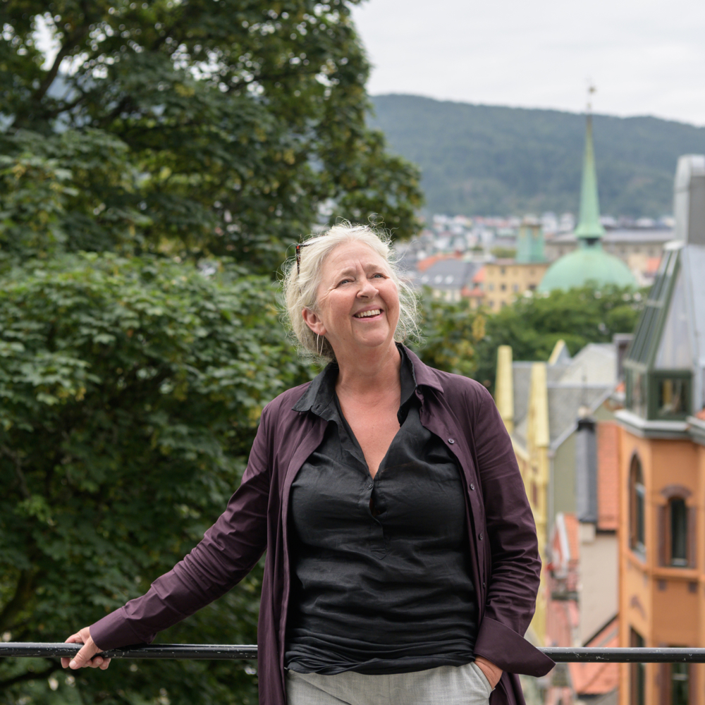 Maria Molden utendørs og lener seg inntil et rekkverk. Foto.