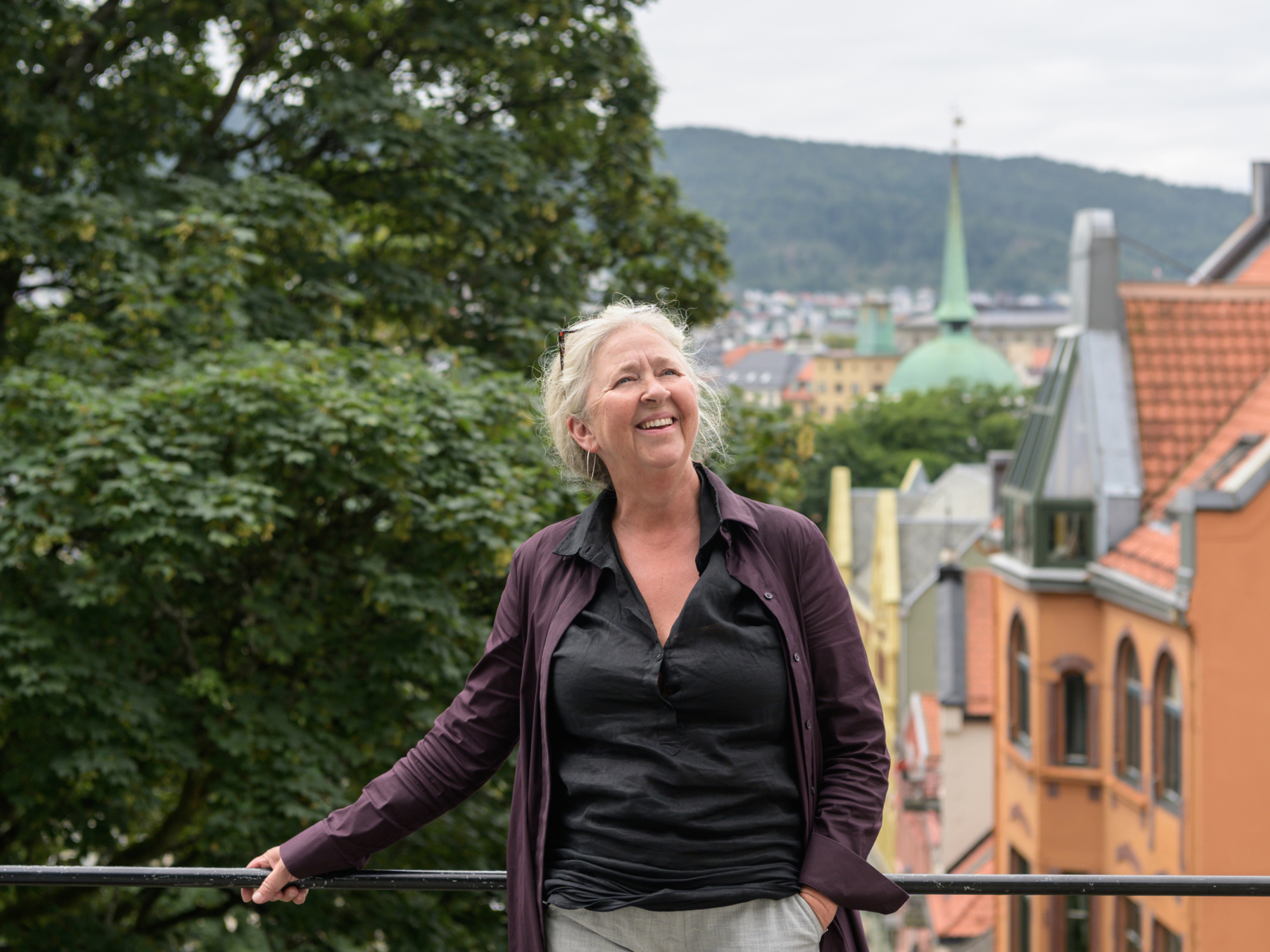 Maria Molden utendørs og lener seg inntil et rekkverk. Foto.