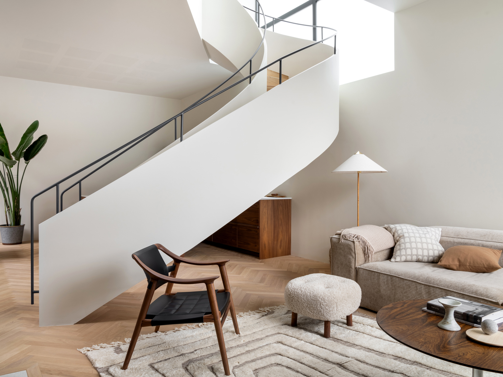 Interiør foto av stue med trapp som svinger seg igjennom rommet, og sofakrok.